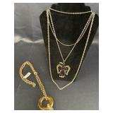 2 gold colored chains w/pendants.  Long chain w/