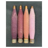 4 vtg wooden textile bobbins w/ purple tone fibers