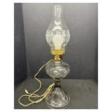 Clear glass hurricane lamp converted into an