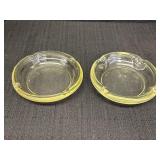 2 pale yellow glass ashtrays, slightly different,
