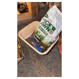 Plastic bucket and open bag of lawn seed