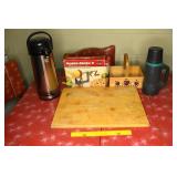 Vintage wooden cutting board, some thermoses,