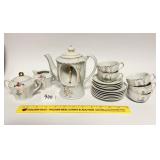 A small vintage tea set. The teapot is musical.