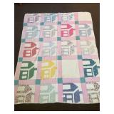 A vintage hand-stitched quilt. It is a house