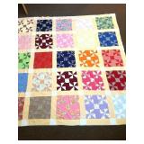 A vintage hand-stitched quilt. It measures