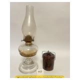 A vintage oil lamp and a stoneware cheese crock.