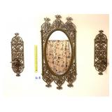 A vintage mirror with matching wall sconces -