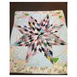 A hand-stitched quilt. A large star pattern. It