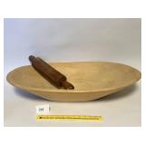 A large vintage wooden dough bowl with rolling