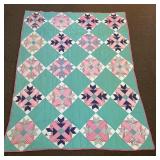 A hand-stitched quilt. It measures approx. 62 x