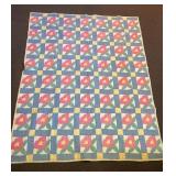 A vintage hand-stitched quilt. It measures