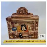 A vintage Colonial fireplace cookie jar. Marked