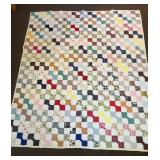 A hand-stitched bow tie quilt. Measures