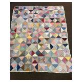 a vintage hand-stitched quilt. It measures