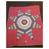 A hand-stitched lone-star quilt. It measures 65 x