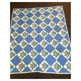 A vintage hand-stitched quilt. It measures
