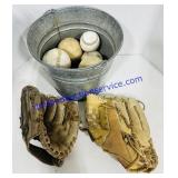 Baseball Gloves with a Bucket of Balls