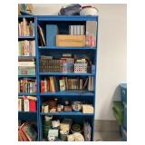 METAL SHELVING UNIT WITH LARGE SELECTION OF BOOKS,