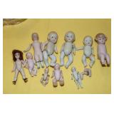 Lot of antique jointed bisque dolls in a glass