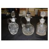 2 Clear glass cruets and a cologne/perfume bottle