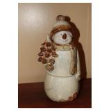 Ceramic snowman holding a Christmas tree figurine