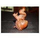 Carved boxwood squirrel on an acorn