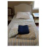 Twin bed with upholsterd headboard and linens
