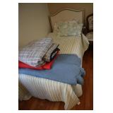 Twin bed with upholsterd headboard and linens