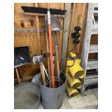 Galvanized trash can with yard tools including