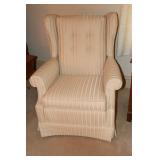 Swivel and rocking wingback chair and a tan