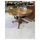 Oak pedestal dining table with round top and 2