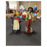 Chalkware man and woman carrying balloons