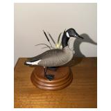 Miniature goose carving standing by reeds on a
