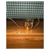 Brass watering can with copper floral motif