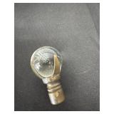 knob featuring a glass orb held by metal prongs.