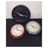 Three battery operated wall clocks the largest is