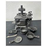 Miniature cast-iron stove with several accessory