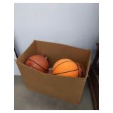 Large box of basketballs footballs and a baseball