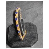 Gold tone tennis bracelet w/sapphire color stones