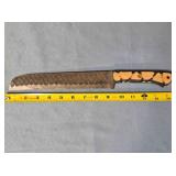 Serrated bread knife. Carved wood handle.