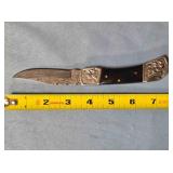 Clip point lockback folding knife w/jimping spine.