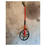 Roll-a-tape measure wheel