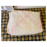 stack of older quilts, some have a lot of wear;
