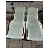 2 green and plastic patio lounge chairs. Plastic