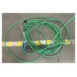 Green garden hose and two attachment nozzles