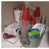 Assorted cups plates cutlery and bags in a