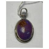 This is a sterling silver pendant featuring a