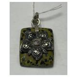 This is a sterling silver pendant with a green