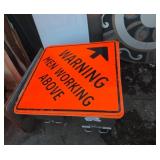 Warning men working above metal sign