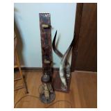 Taxidermy art: wall mounted horns, hoof rack and hoof lamp base